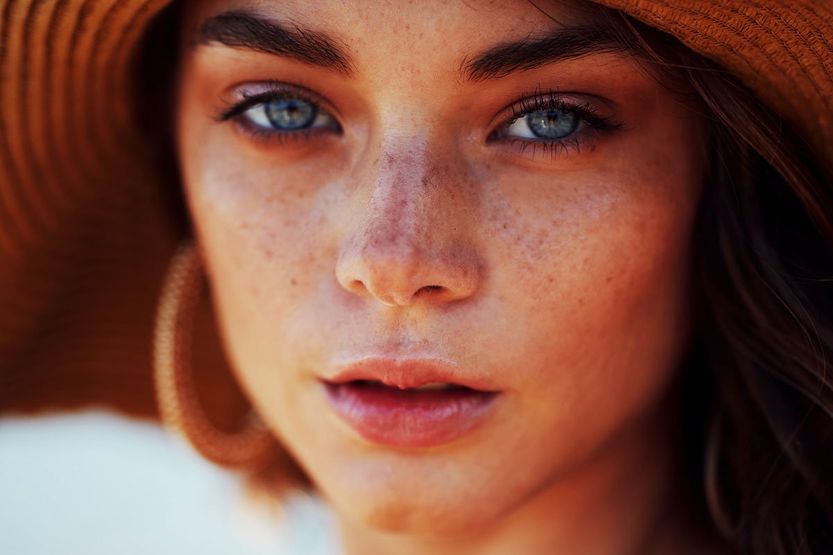 image of woman staring at camera in sun hat