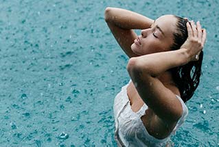 Image of a woman in a pool while it's raining