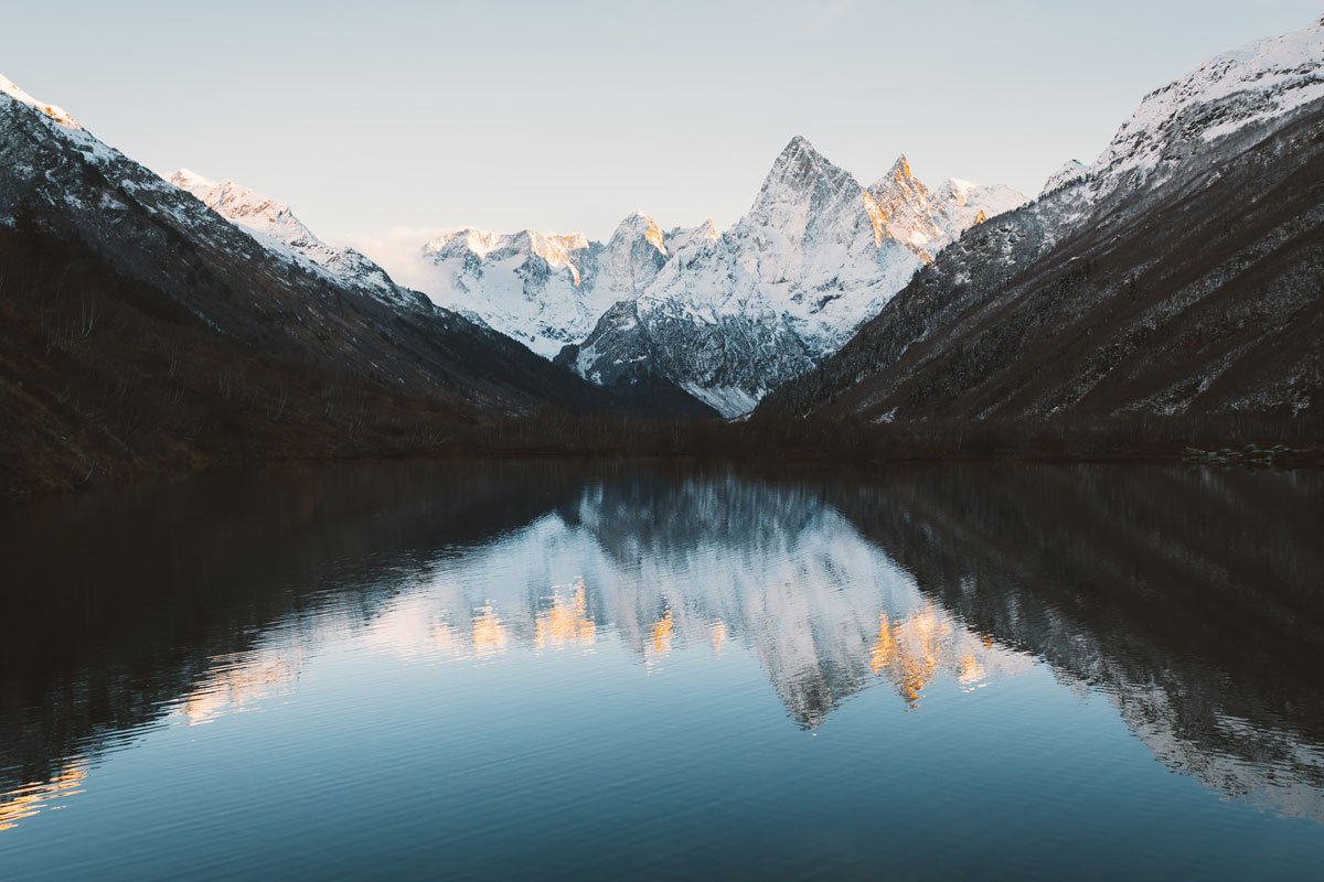 image of mirror-like lake overlooked by dark mountain